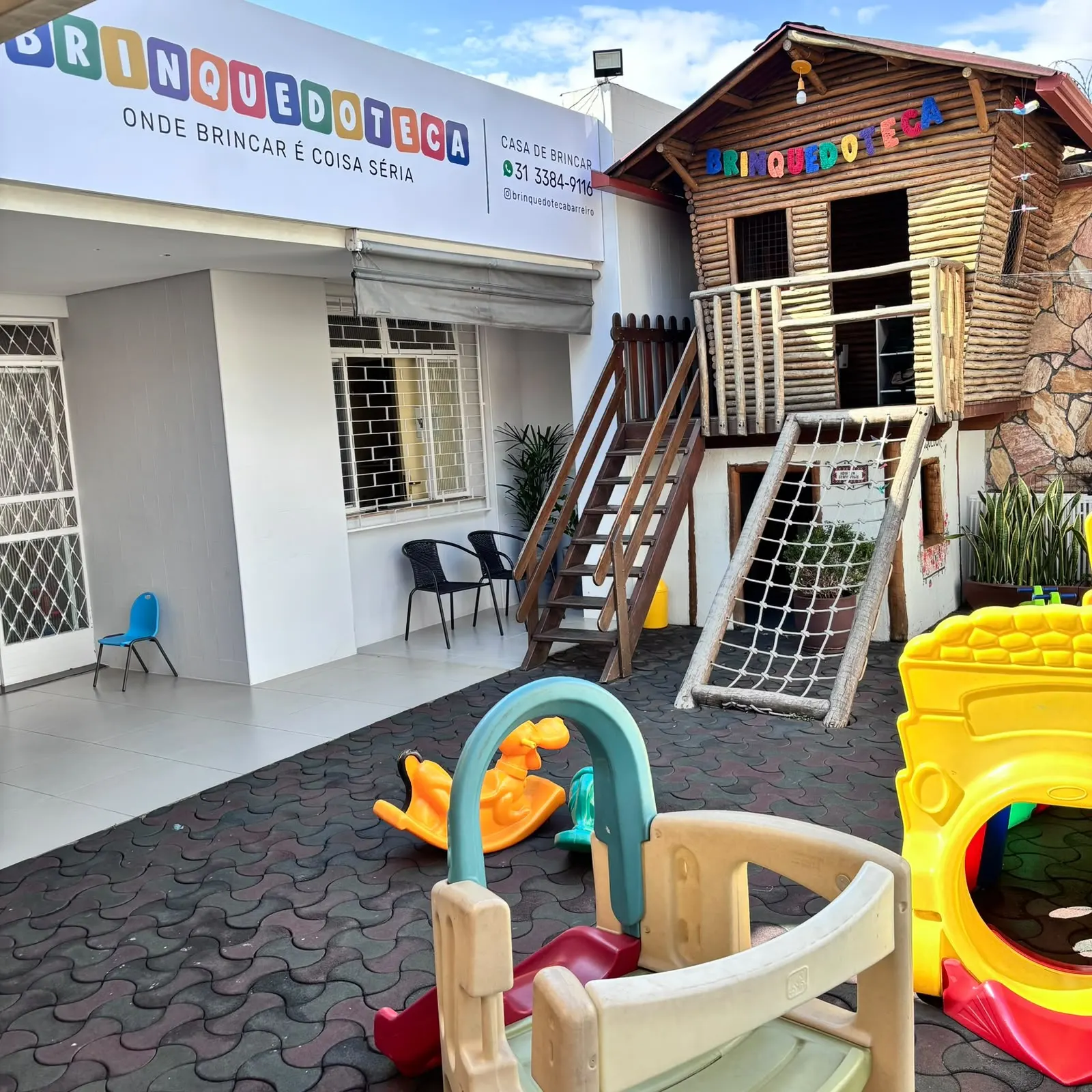 A fachada colorida da Brinquedoteca, com a casinha de madeira ao lado