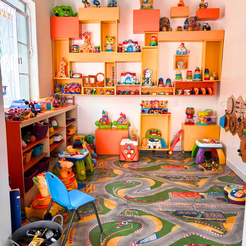 Prateleiras de brinquedos coloridos e tapete de pista